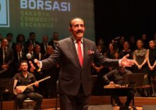 Sakarya Ticaret Borsası logosu ve etkinlik sahnesinde konuşmacı.